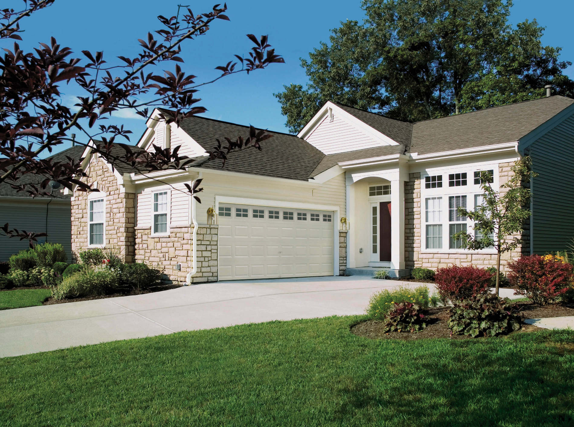 small home with classic clopay white steel garage door