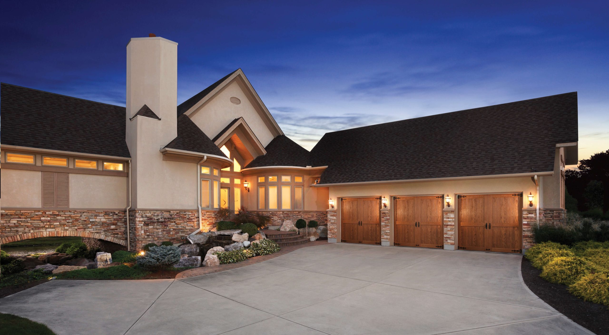 large modern home with wooden clopay garage doors
