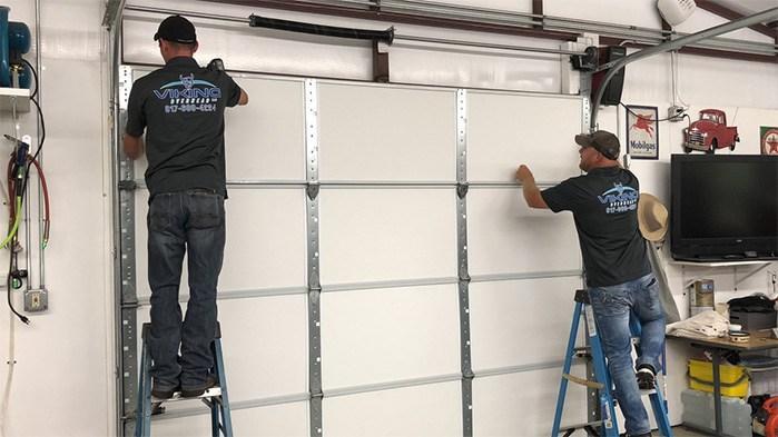 two workers installing a garage door